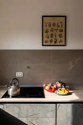 a kitchen counter with a tea kettle and a plate of fruit at Vittoria C Elegant Apt Near Vatican & Dome View in Rome