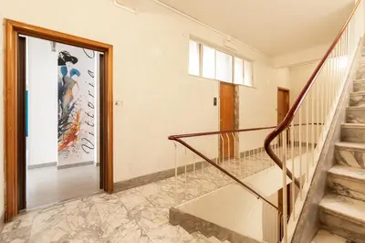 a staircase in a house with a painting on the wall at Vittoria C Elegant Apt Near Vatican & Dome View in Rome