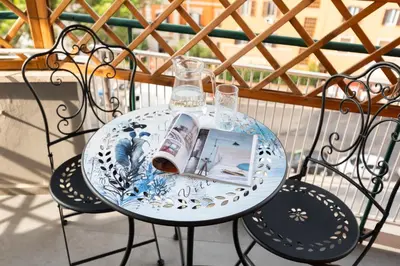 a glass table with a magazine on it on a balcony at Vittoria C Elegant Apt Near Vatican & Dome View in Rome