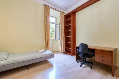 a bedroom with a bed and a desk and a chair at Relax a Trastevere in Rome
