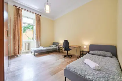 a bedroom with two beds and a desk and a window at Relax a Trastevere in Rome