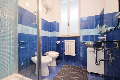 a blue tiled bathroom with a toilet and a shower at Penthouse 5 minutes from the Vatican - 5 bedrooms & 4 bathrooms in Rome