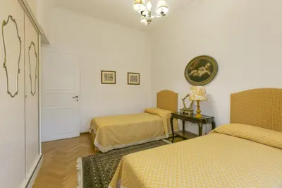 a bedroom with two beds and a table with a lamp at Rome Garden Hill in Rome