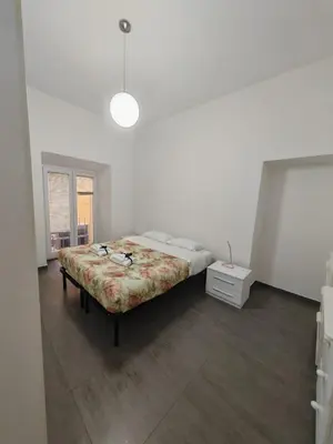 a white room with a bed and a window at Emilia's Dream Apartment in Rome