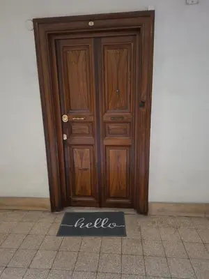 a wooden door with a sign in front of it at Emilia's Dream Apartment in Rome