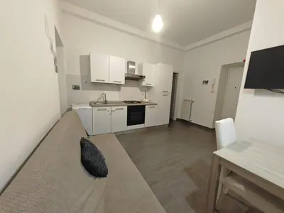 a white kitchen with a black pillow on a couch at Emilia's Dream Apartment in Rome