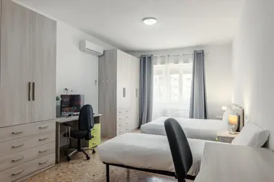 a bedroom with two beds and a desk with a computer at Veturia in Rome