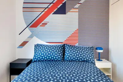 a bedroom with a blue bed and a colorful wall at Cielo di Roma con Terrazzo - Self Check-in 24h in Rome