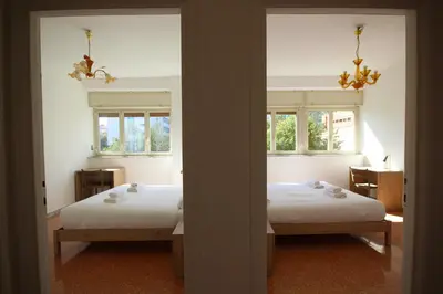two beds in a room with two windows at HC - Stadio Olimpico Huge Apartment NEW in Rome