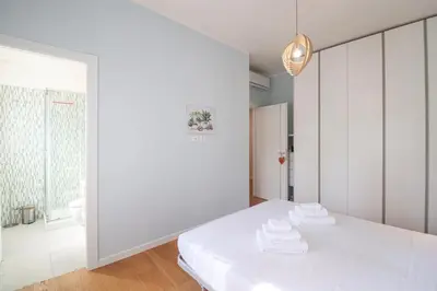 a white room with a bed with towels on it at Elegant & Chic 2 Suites Apartment - 5min to Station, AC, Wi-Fi in Rome