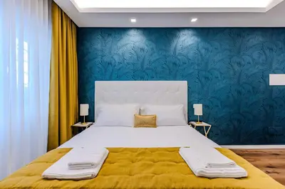 a bedroom with a large bed and a blue wall at G MARCONI Rooms & Suites in Rome