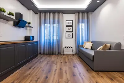 a living room with a couch and a kitchen at G MARCONI Rooms & Suites in Rome