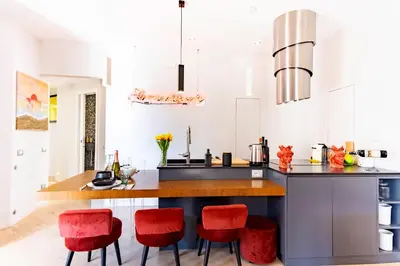 a kitchen with red bar stools and a counter at Elegantis Penthouse in the Heart of Rome With Private Terrace and View in Rome