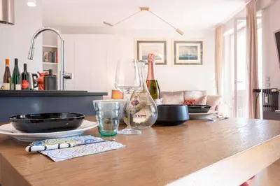 a kitchen with a wooden table with wine glasses at Elegantis Penthouse in the Heart of Rome With Private Terrace and View in Rome