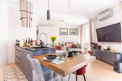 a kitchen and living room with a wooden table at Elegantis Penthouse in the Heart of Rome With Private Terrace and View in Rome