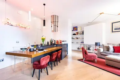 a kitchen and living room with a dining table and chairs at Elegantis Penthouse in the Heart of Rome With Private Terrace and View in Rome