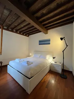 a bedroom with a white bed and a lamp at La Dolce Vita - Rione Campo Marzio the Beating Heart of Rome in Rome