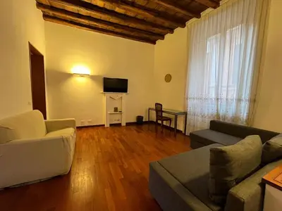 a living room with a couch and a table with a television at La Dolce Vita - Rione Campo Marzio the Beating Heart of Rome in Rome