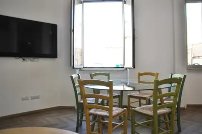 a dining room with a table and chairs and a flat screen tv at Giulio al MAXXI Apartment Flaminio in Rome