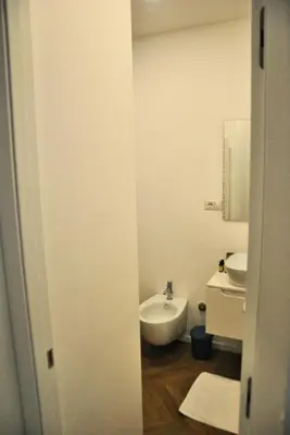a white bathroom with a sink and a mirror at Giulio al MAXXI Apartment Flaminio in Rome
