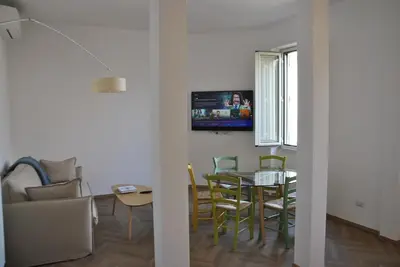 a living room with a table and chairs and a television at Giulio al MAXXI Apartment Flaminio in Rome