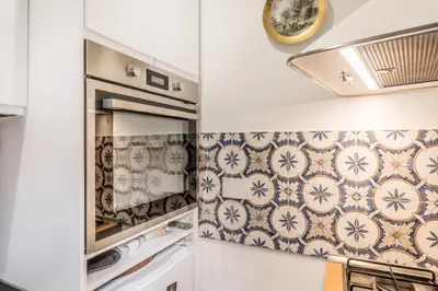 a kitchen with tiles on the wall and a stove at Spagna Suite Dream by Ghor in Rome