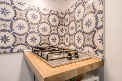 a kitchen with blue and white tiles on the wall at Spagna Suite Dream by Ghor in Rome
