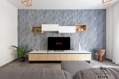 a living room with a tv on a wall at GFC Eternal Rome Apartment - 5min to Tiburtina Station MetroB, 2 Bathrooms, Terrace, A-C in Rome
