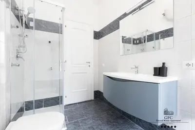 a white bathroom with a sink and a shower at GFC Eternal Rome Apartment - 5min to Tiburtina Station MetroB, 2 Bathrooms, Terrace, A-C in Rome