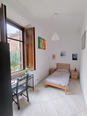 a bedroom with a bed and a desk and a window at Casa del Vinile Roma in Rome
