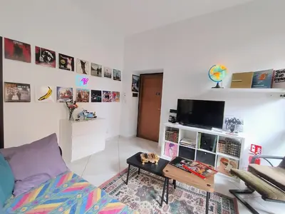 a living room with a couch and a tv at Casa del Vinile Roma in Rome