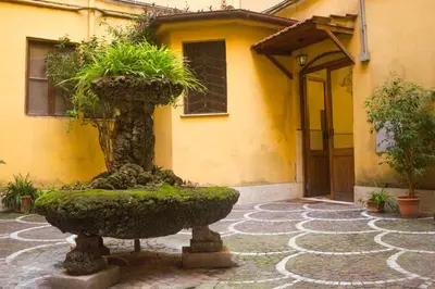 a fountain in a courtyard in front of a building at Your cozy place at the Vatican in Rome