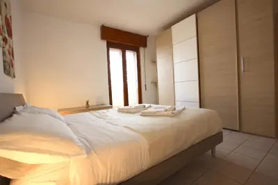 a bedroom with a bed with white sheets and a window at Manuela Holiday House in Rome