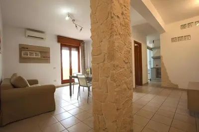 a living room with a couch and a stone pillar at Manuela Holiday House in Rome