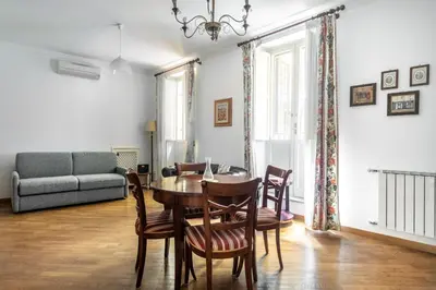 a living room with a table and chairs and a couch at Colosseum Monti large flat in Rome