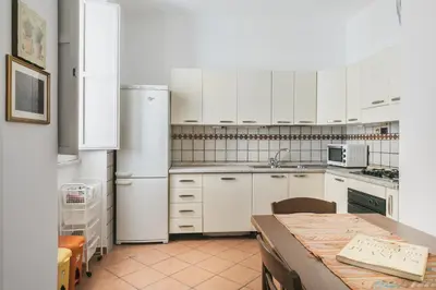 a kitchen with white appliances and a table in it at Colosseum Monti large flat in Rome