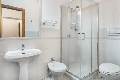 a bathroom with a sink and a toilet and a shower at Colosseum Monti large flat in Rome
