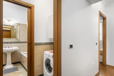 a bathroom with a washing machine and a sink at Colosseum Monti large flat in Rome