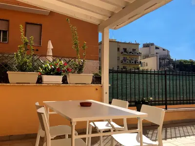 a white table and chairs on a balcony at Wonderful little gem with a large private terrace! in Rome