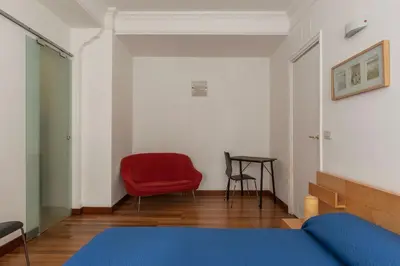 a bedroom with a red chair and a table at GuestHost - Roma MM Repubblica Apartment in Rome