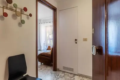 a room with a door and a chair and a mirror at GuestHost - Roma MM Repubblica Apartment in Rome