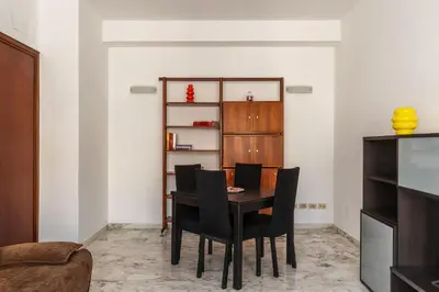 a dining room with a table and black chairs at GuestHost - Roma MM Repubblica Apartment in Rome