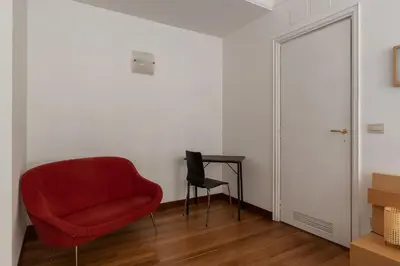 a red chair and a table in a room at GuestHost - Roma MM Repubblica Apartment in Rome