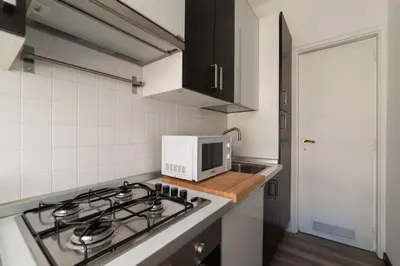 a kitchen with a stove top and a microwave at GuestHost - Roma MM Repubblica Apartment in Rome