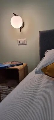 a bedroom with a bed and a clock on the wall at Yuki Apartment in Rome