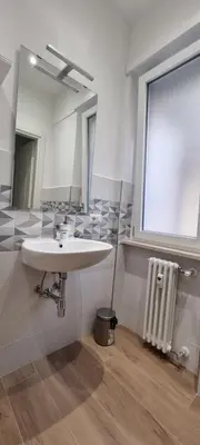 a bathroom with a sink and a mirror at Yuki Apartment in Rome