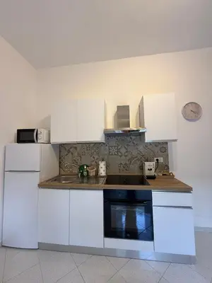 a kitchen with white cabinets and a sink at La Martinella a Roma in Rome