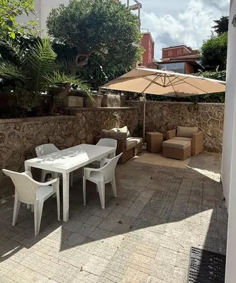 a table and chairs and an umbrella on a patio at La Martinella a Roma in Rome