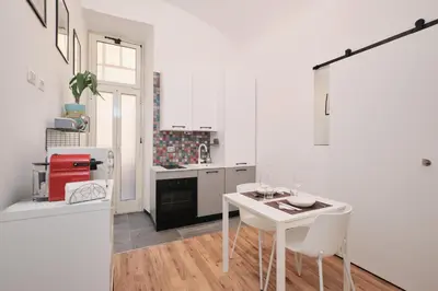 a white kitchen with a white table and chairs at Termini Station 5 minutes - Free Wi-Fi & Netflix in Rome
