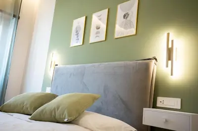 a bed with two pillows and three pictures on the wall at C&P Luxury Guest House Rome in Rome